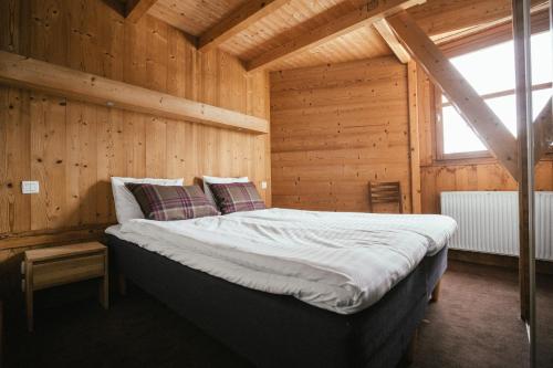 sypialnia z łóżkiem w drewnianym pokoju w obiekcie Langley Hôtel Victors w mieście Val dʼIsère