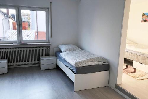 a small bedroom with a bed and a window at 3 Zimmer Apartment mit Küche, TV & WLAN in Egelsbach