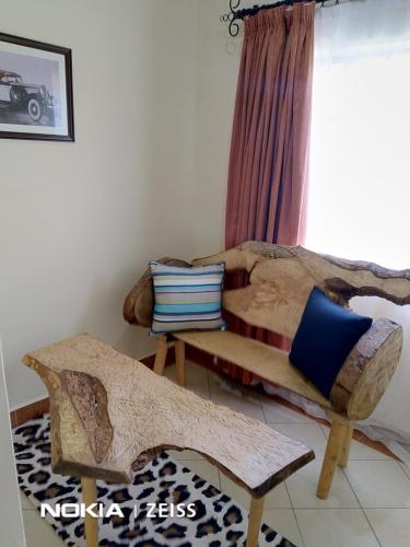 ein Wohnzimmer mit 2 Betten und einem Stuhl in der Unterkunft Machakos Suites Luxury Hotel in Machakos