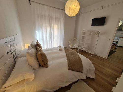 1 dormitorio con 1 cama blanca grande con almohadas en Alojamientos Segóbriga Rural (Montaña), en Segorbe