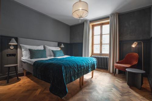 - une chambre avec un lit, une chaise et une fenêtre dans l'établissement Langley Hotel Gustavia, à Chamonix-Mont-Blanc
