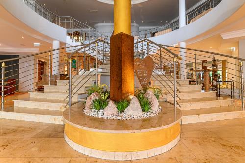 a spiral staircase with a large fountain in a building at Wohlfühlhotel Schiestl in Fügen