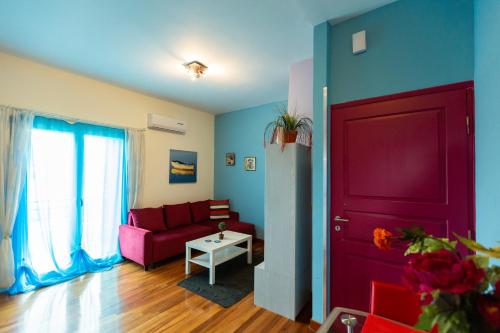 a living room with a red couch and a red door at La Terra Nostra in Korinthos
