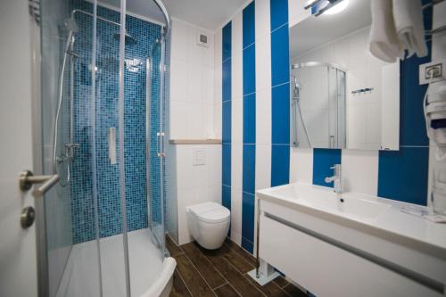 uma casa de banho com um WC, um lavatório e um chuveiro em HOTEL IVANDO - K&S em Drvenik