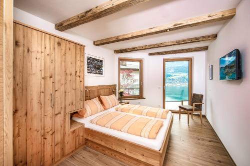 a bed in a room with a wooden wall at Premium Apartments Adlerhorst by we rent in Zell am See