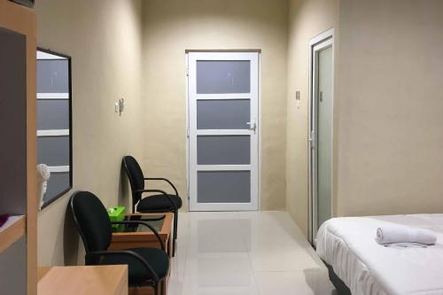 a bedroom with a bed and a desk and a window at Wisma Syariah UINSU Medan Mitra RedDoorz in Medan