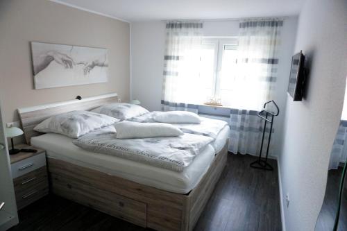 ラーンシュタインにあるFerienwohnung Perschのベッドルーム1室(白いシーツ付きのベッド1台、窓付)