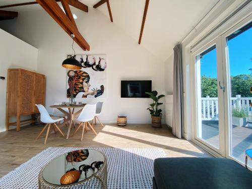 a living room with a table and a dining room at Luxurious historical Loft close to the beach!! in Wassenaar