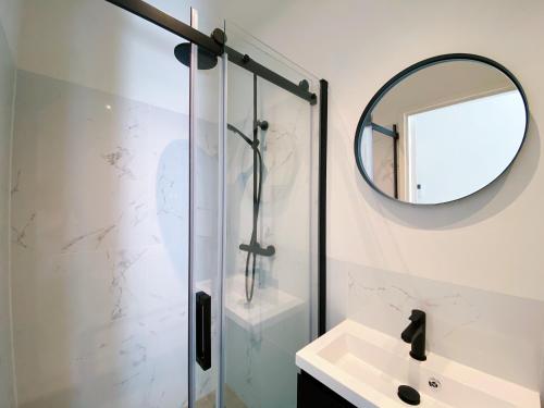 a bathroom with a shower and a sink and a mirror at Luxurious historical Loft close to the beach!! in Wassenaar