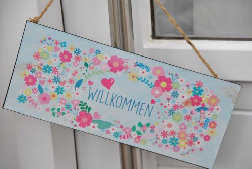 a sign with a bunch of flowers on a window at Ferienwohnung Finja in Bad Dürrheim