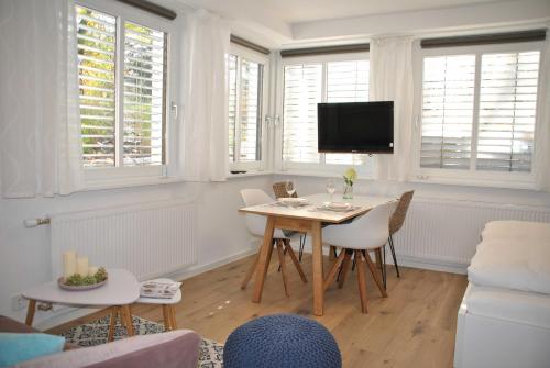 a living room with a table and chairs and a tv at Ferienwohnung Finja in Bad Dürrheim