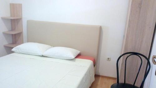 1 cama blanca con 2 almohadas en una habitación en One bedroom apartement with sea view enclosed garden and wifi at Zadar 3 km away from the beach, en Zadar