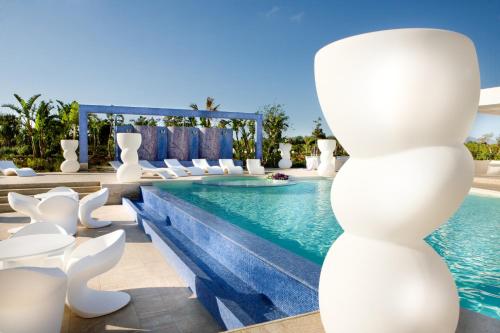 パルティニーコにある3 bedrooms apartement with shared pool enclosed garden and wifi at Partinico 6 km away from the beachのリゾートのプール(白い椅子、スイミングプール付)