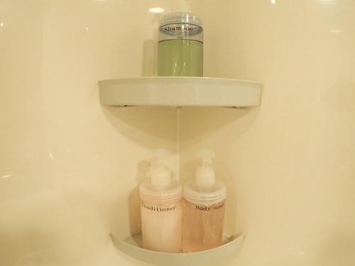 a shelf in a bathroom with bottles and a sink at Field Hakone Resort in Hakone