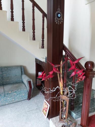 a stairway with a vase with red flowers on it at Tarana Homestay in Gonikoppal