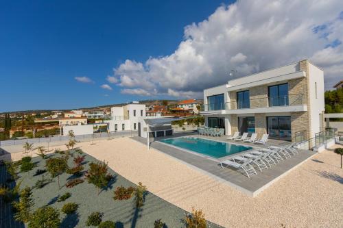 a villa with a swimming pool and a house at Villa Andromeda, Sea Caves in Peyia