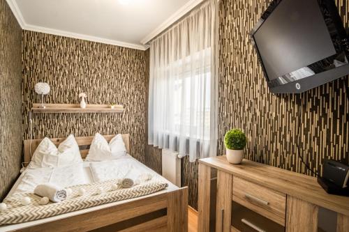 a bedroom with a bed and a tv on a wall at MyFlat Club 218 Golden Beach Wellness Apartment in Siófok