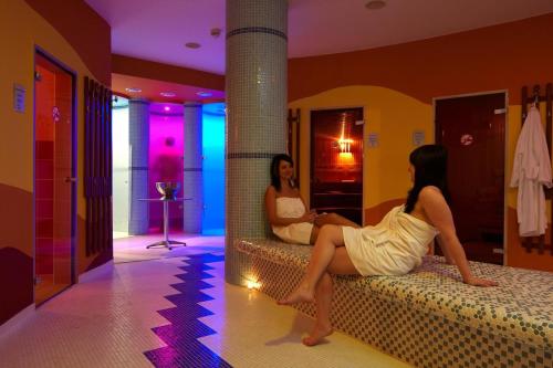 two women sitting on a bed in a room at Klostermann Wellness&Spa in Frymburk