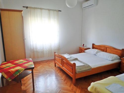 a bedroom with two beds and a large window at Apartments Nada in Starigrad-Paklenica