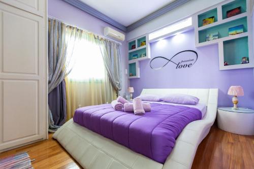 a purple bedroom with a large bed with purple sheets at La Terra Nostra in Korinthos
