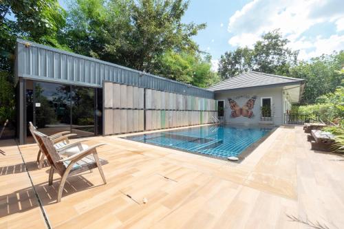 a swimming pool on a deck with a house at Capital O 75378 Thawapee Resort in Rayong