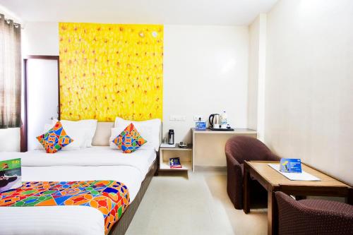 a hotel room with two beds and a table at Hotel Omni Plaza in Jodhpur