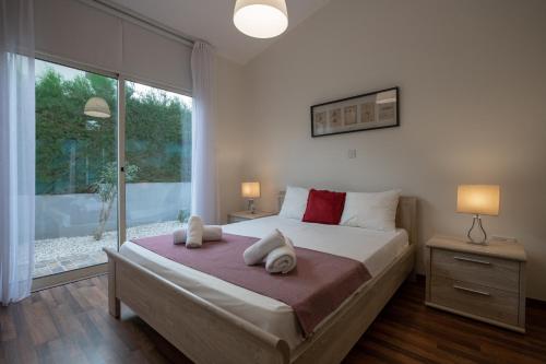 a bedroom with a large bed and a large window at Villa Arsinoe by Agroholidays in Pissouri