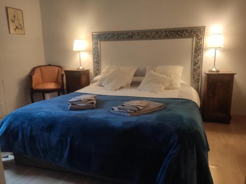1 dormitorio con 1 cama grande y 2 albornoces. en Les chambres de la Caussade en Lautrec