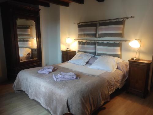 1 dormitorio con 1 cama con 2 toallas en Les chambres de la Caussade en Lautrec
