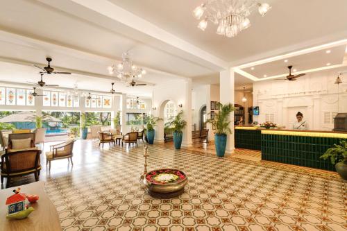 a large lobby with a dining area and a bar at Heritage Village Resort & Spa Goa in Cansaulim