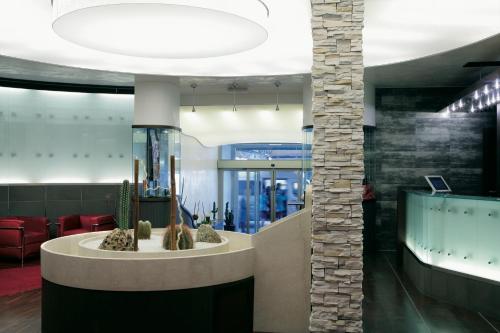 a lobby with a waiting area with a cactus at Best Western Gorizia Palace in Gorizia