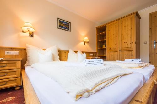 two beds in a bedroom with white sheets at Landgasthof Bierfriedl in Pruggern
