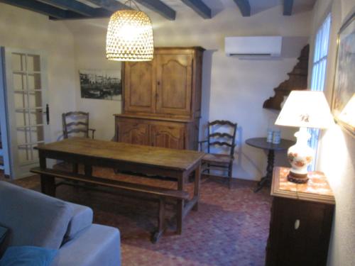 a living room with a table and a large cabinet at la villa rose in Saint-Trojan-les-Bains