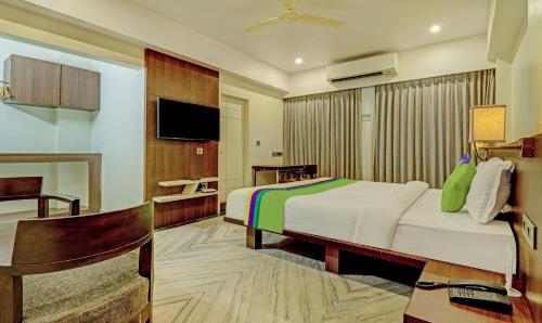 a hotel room with a bed and a desk at Treebo Seaesta RK Beach in Visakhapatnam