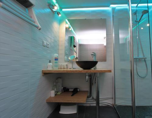 une salle de bain avec un lavabo et une douche en verre dans l'établissement Escalille le Voltaire, à Lille