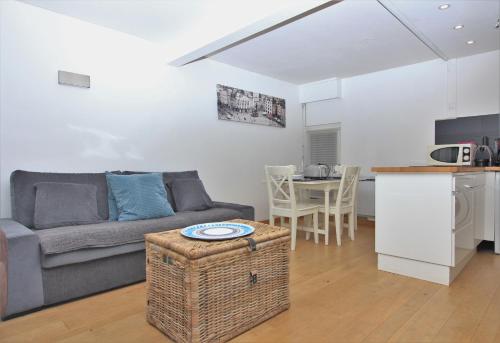 un salon et une cuisine avec un canapé et une table dans l'établissement Escalille le Voltaire, à Lille