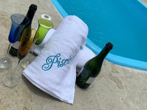 a towel and two bottles of wine and glasses at Casa praia do espelho, Outeiro das Brisas in Praia do Espelho