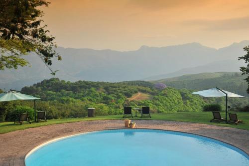 uma piscina com vista para as montanhas em Coach House Hotel & SPA Tzaneen em Tzaneen