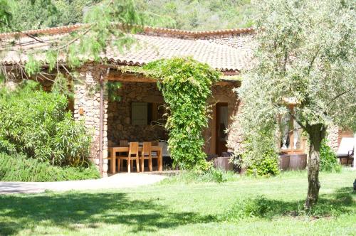 une maison en pierre avec une table en face dans l'établissement Domaine Codaleone, à Serriera
