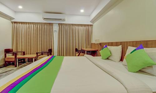 a bedroom with a large bed with colorful pillows at Treebo Seaesta RK Beach in Visakhapatnam
