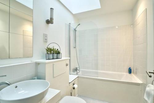 a white bathroom with a sink and a toilet and a tub at Ironbridge Townhouse with Roof Terrace and Parking in Ironbridge