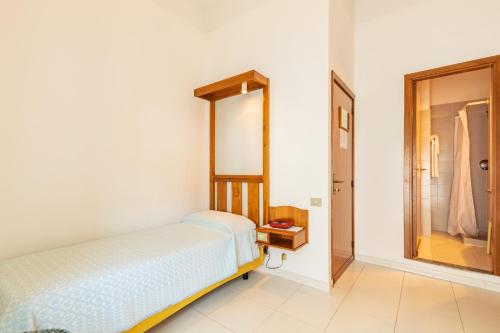a bedroom with a bed and a mirror at Albergo Miramare in Cala Gonone