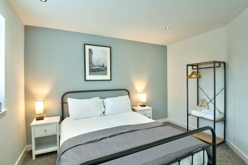 a bedroom with a bed with two tables and two lamps at School Path Ironbridge Townhouse with Roof Terrace in Ironbridge