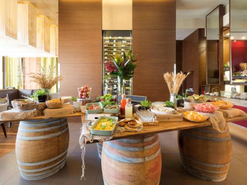 a buffet with bowls of food on top of wine barrels at Pullman Sydney Olympic Park in Sydney