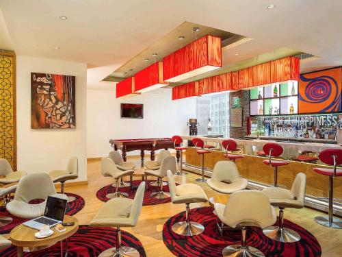 a bar with chairs and a piano in a room at ibis Bengaluru Hosur Road - An Accor Brand in Bengaluru