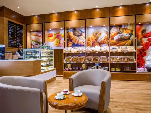 a restaurant with a table and two chairs and a counter at Sofitel Abu Dhabi Corniche in Abu Dhabi