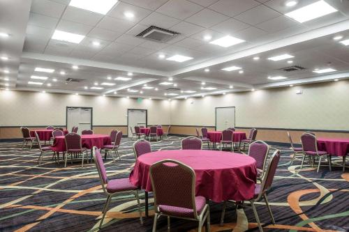 a room with pink tables and chairs in it at Clarion Hotel Fort Mill Near Amusement Park in Fort Mill