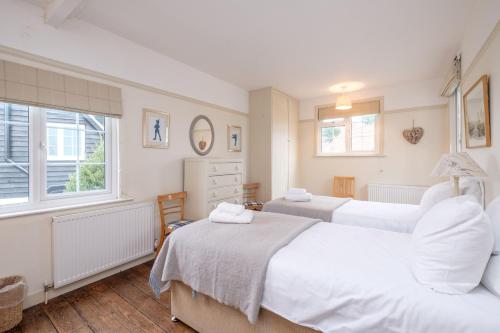 Un dormitorio con dos camas y una ventana. en Sanctuary House, en Thorpeness