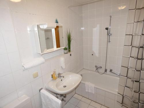 a white bathroom with a sink and a bath tub at SUNNYHOME Monteurwohnungen und Apartments in Wackersdorf in Wackersdorf