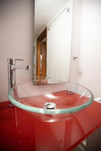 a glass sink in a bathroom with a mirror at Sun Villa in Neon Oitilon